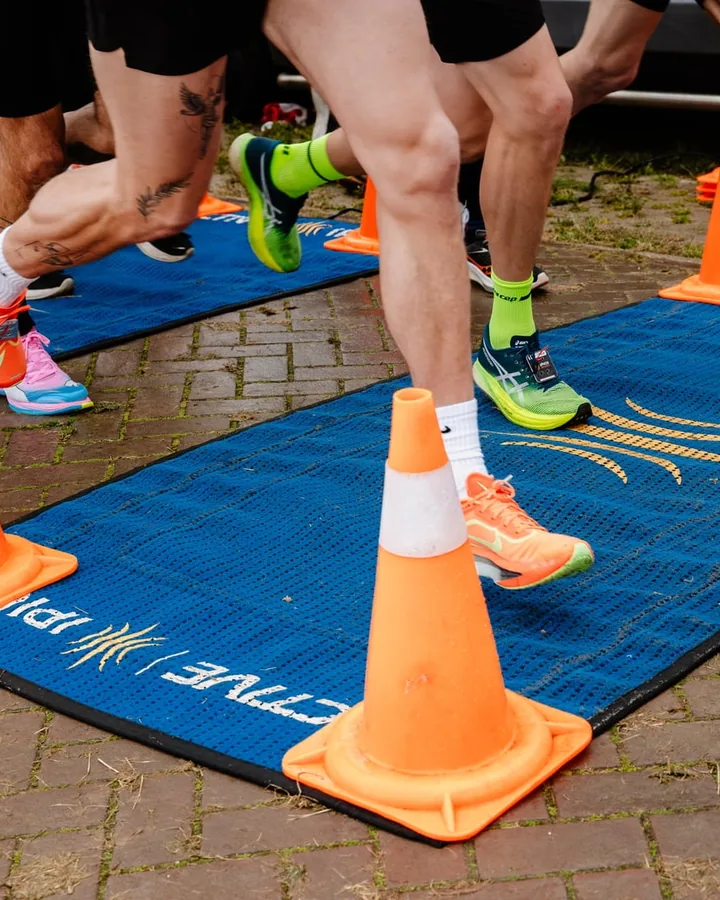 Lopers passeren de tijdwaarnemingsmatten tussen pionnen