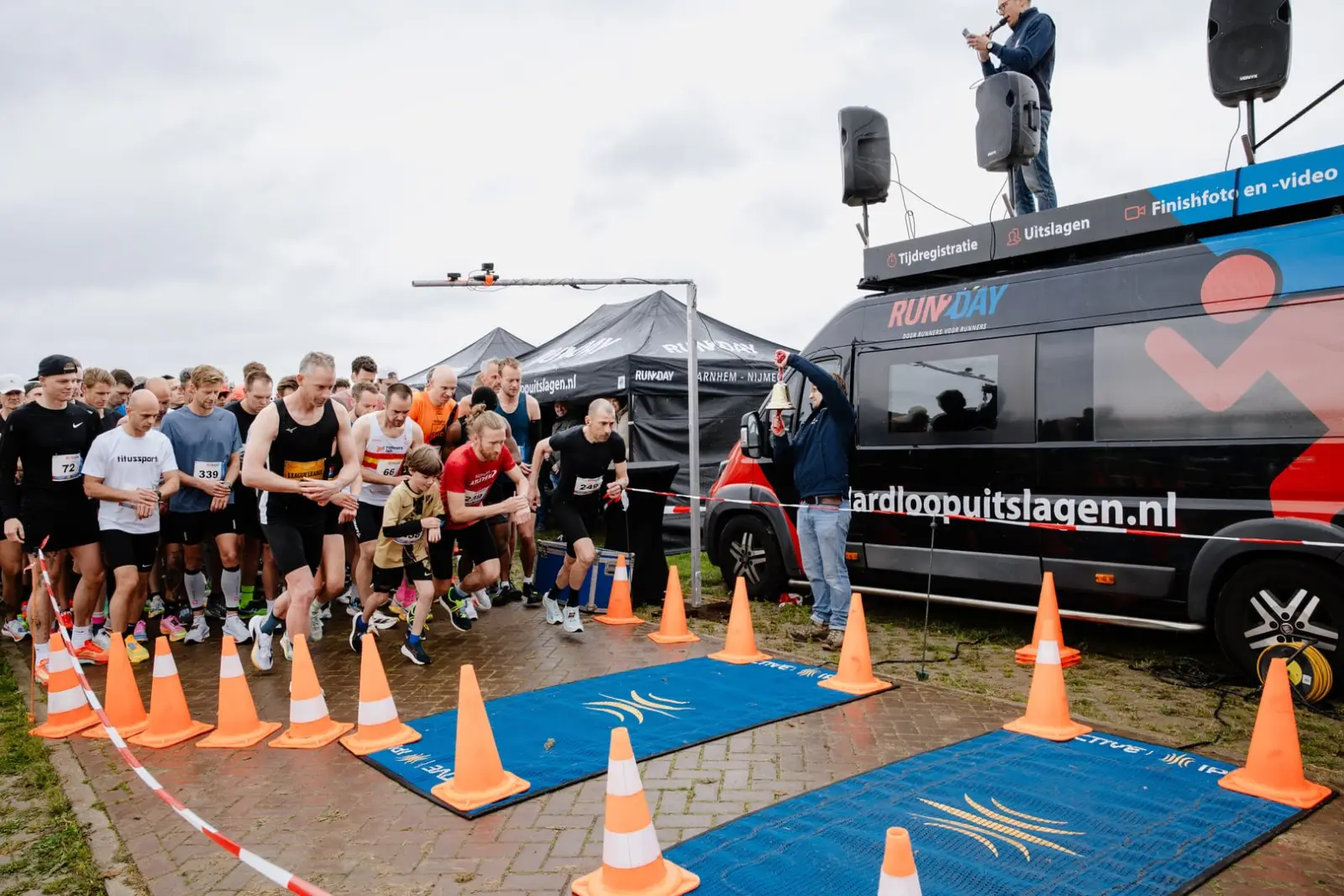 Startveld met tijdwaarnemingsmatten en Hardloopuitslagen.nl bus