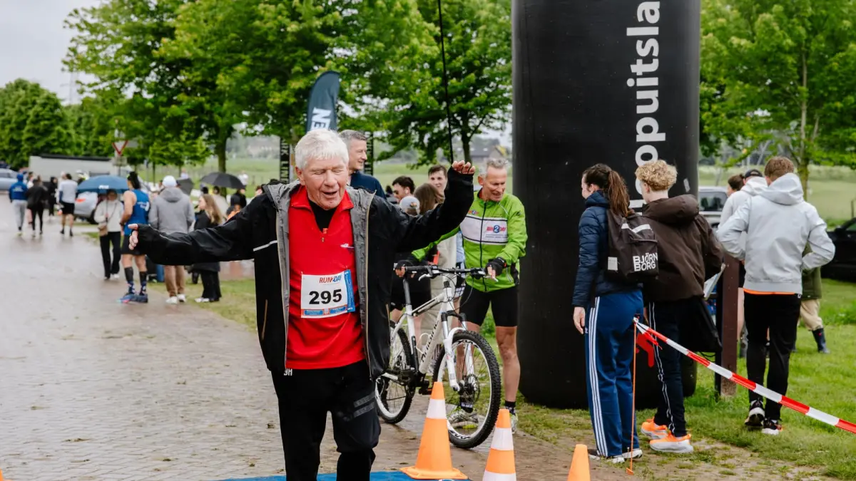 Finishopstelling met hardlopers, tijdwaarneming en publiekszone bij een evenement