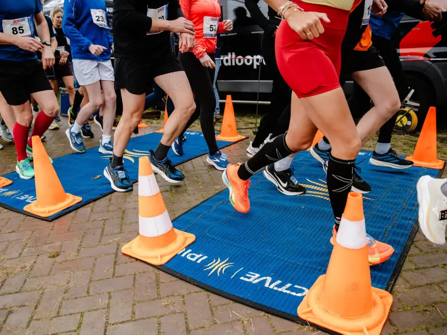 Lopersvoeten op de tijdwaarnemingsmat bij de start